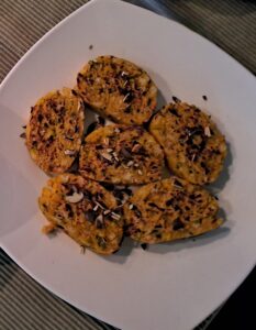 Der Teller mit einigen Scheiben Kürbisknödel steht zum Essen bereit