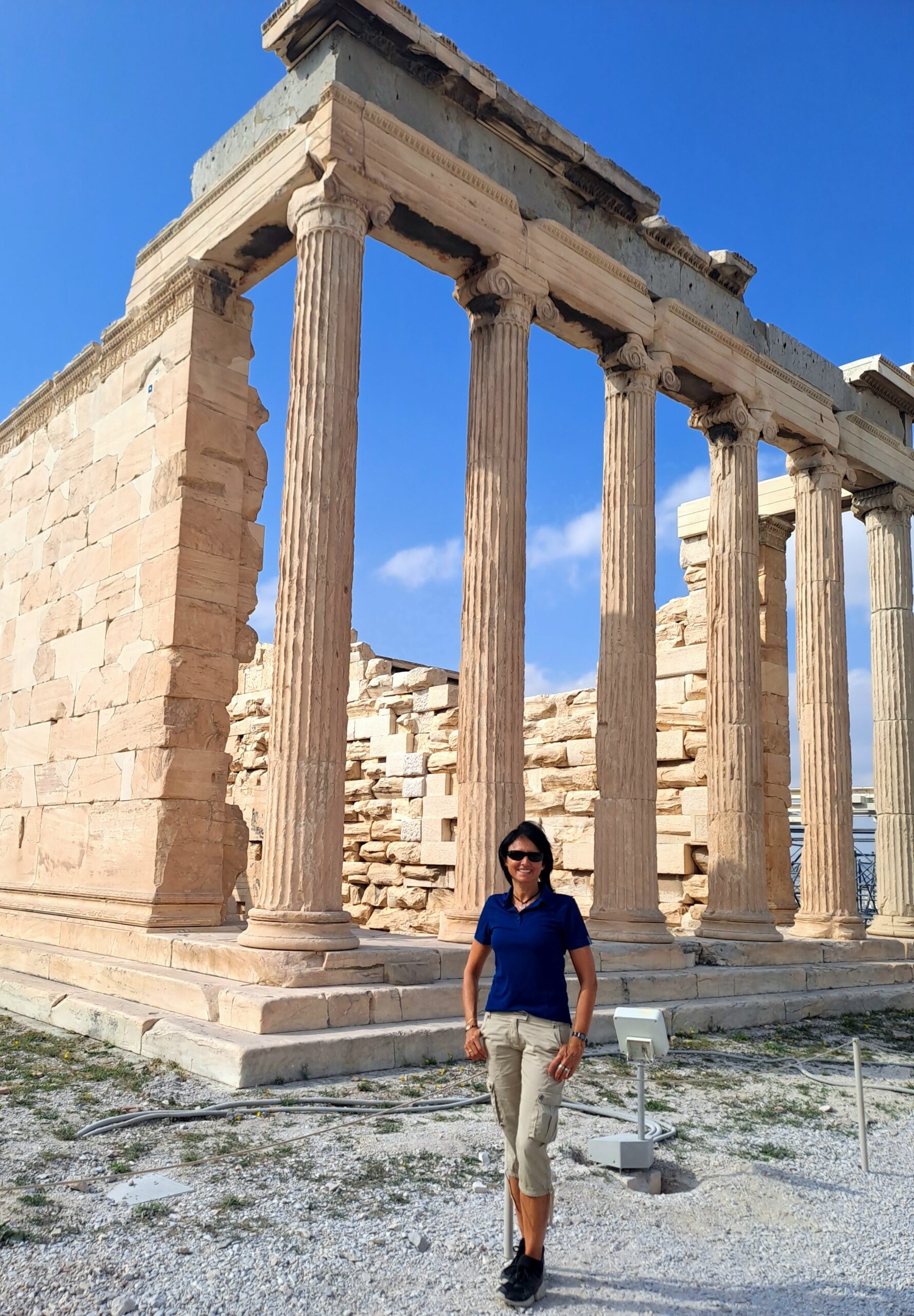 Karin steht mit Sonnenbrille an einem wunderbaren Herbsttag vor der Akropolis