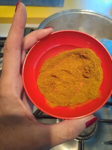 Currypulver, das zum Huhnfleisch gegeben wird