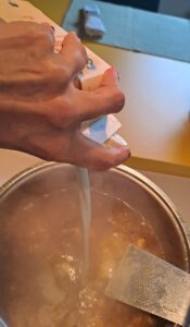 flüssige Sahne wird zum Hühnerfleisch gegeben
