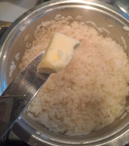 in beinahe gar gekochten Reis wird Butter eingerührt