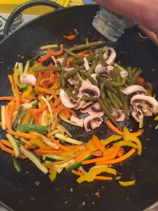 grüne Bohnen und Champignon in den Wok mischen