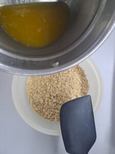 geschmolzene Butter zu den Kekskrümeln