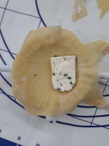 Form mit Teig ausgelegt und Käse gefüllt