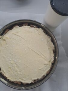 etwas Staubzucker auf vorbereiteten Käsekuchen