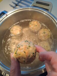 Einzeln werden vorgeformte Knödel ins Salzwasser gegeben