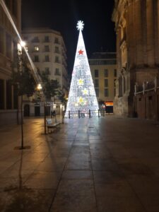in einer Straße in der Stadt leuchtet ein riesiger Lichter-Weihnachtsbaum