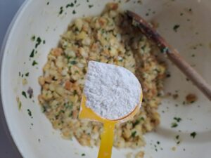 Ein Esslöffel Mehl wird zum Knödelteig gegeben