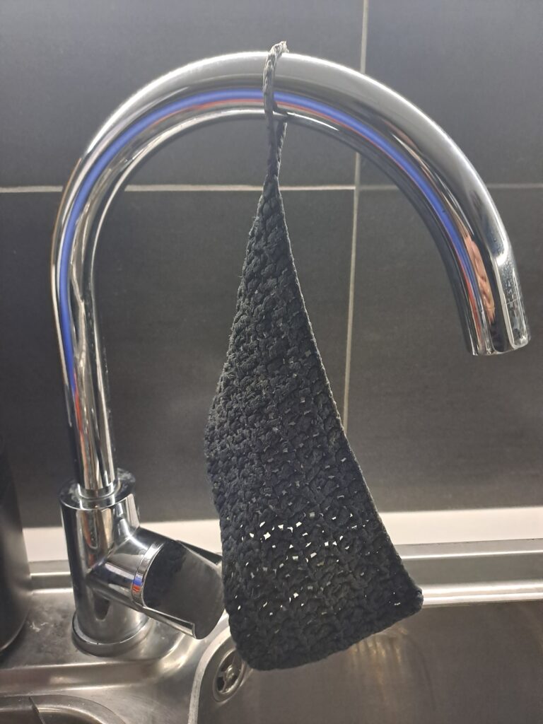 Spüllappen hängt am Wasserhahn
