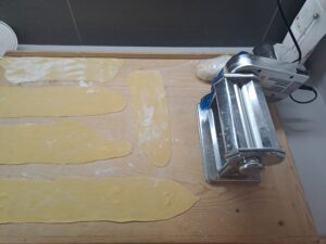 Teigplatten dünn durch die Pastamaschine gekurbelt