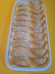 Teigtaschen auf Plastikteller bereit zum Einfrieren