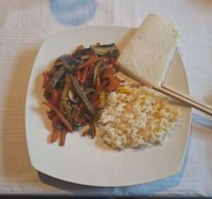 Wokgemüse, kantonesischer Reis und angetoastetes Brot serviert