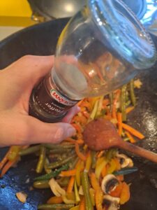 Wokgemüse mit Pfeffer würzen