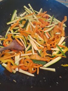 Zucchini zu den Paprika und Karotten mischen