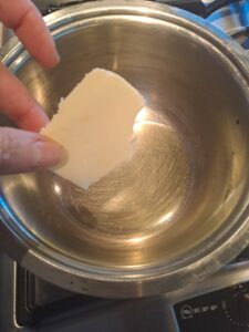 Butter zum Olivenöl im Topf erhitzen