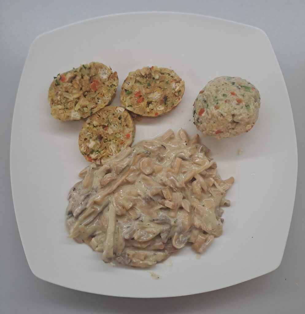 Gemüseknödel mit Champignon-Rahm-Sauce angerichtet