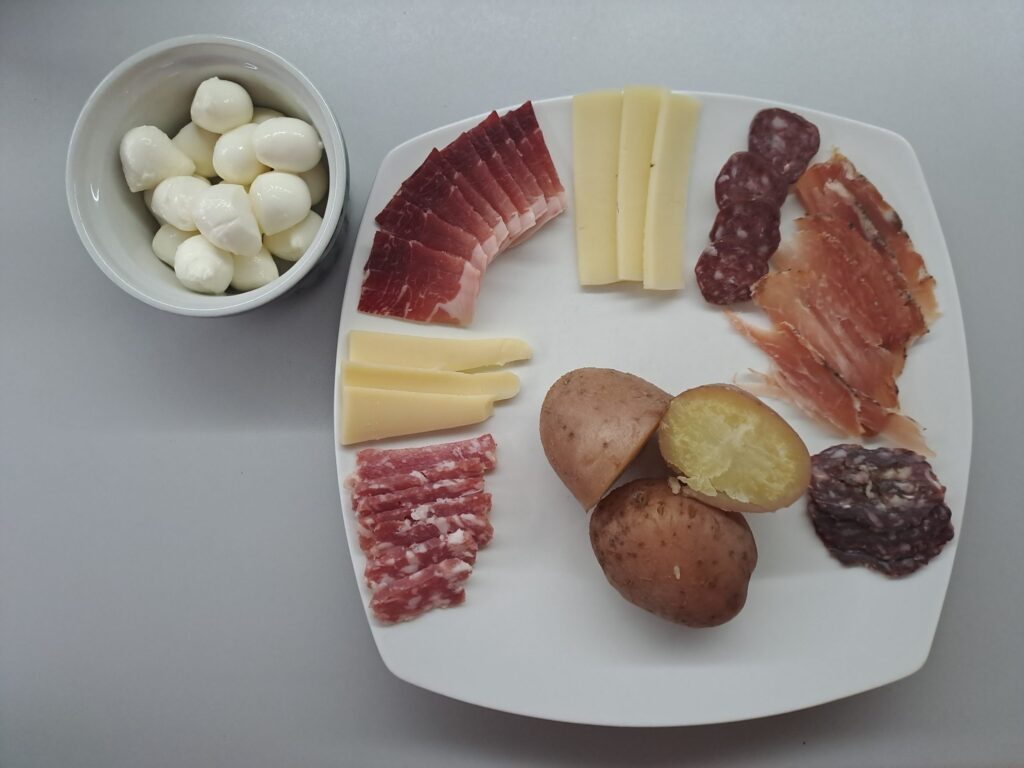 Pellkartoffel mit Aufschnitt angerichtet
