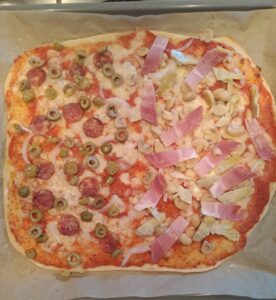gebacken Pizza Hälfte Schinken-, Hälfte Salamivariante