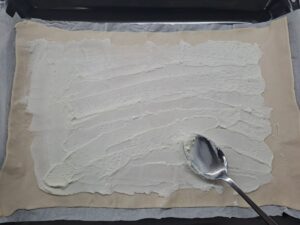 den Teig dünn mit Quark bestreichen