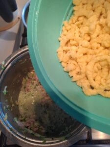 Spatzlen in die Sauce einrühren