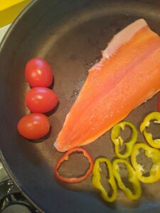 Fisch und Gemüse in der Pfanne braten