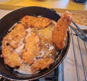 frittierte Schnitzel aus der Pfanne nehmen