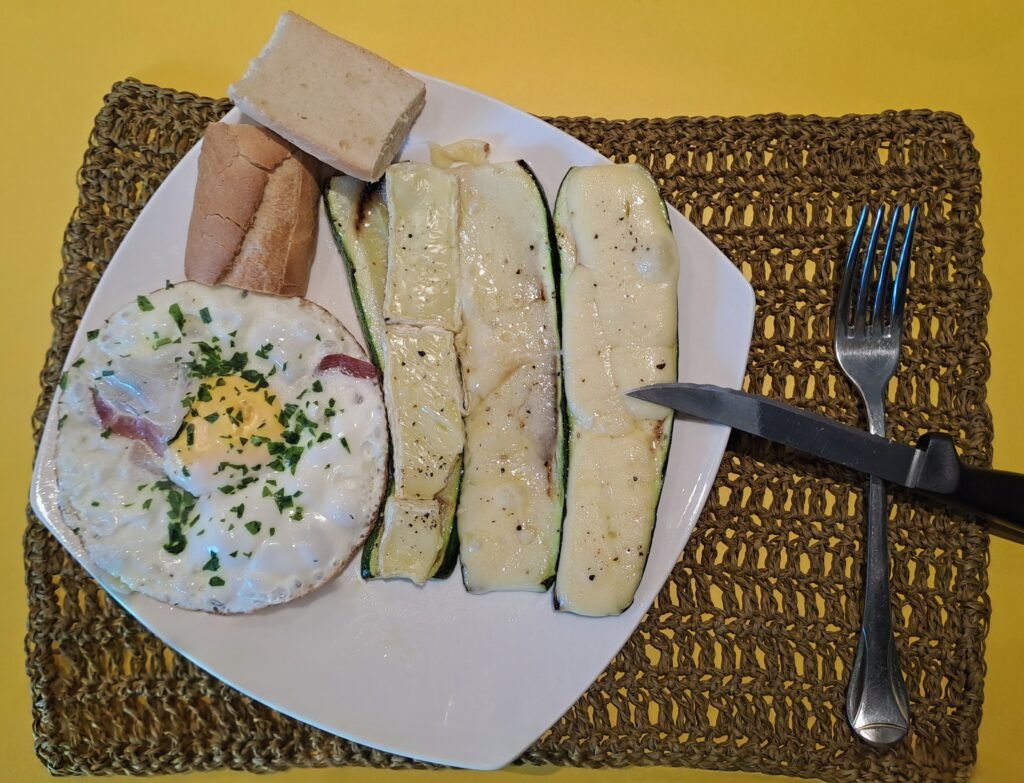 Zucchini überbacken mit Brot und Spiegelei samt Speck