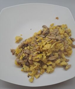 Rührei mit Champignon auf dem Teller angerichtet