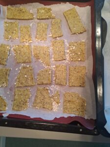 auf dem Backblech ausgebreitete rohe Kräcker