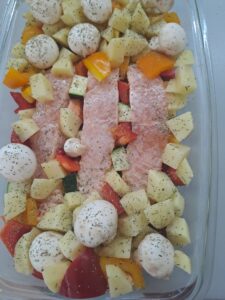 Lachs und Gemüse in der Auflaufform angerichtet und gewürzt