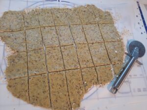 mit dem Pizzaschneider den Teig schneiden