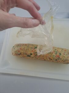 Gemüse-Servietten-Knödel aus der Folie entnehmen
