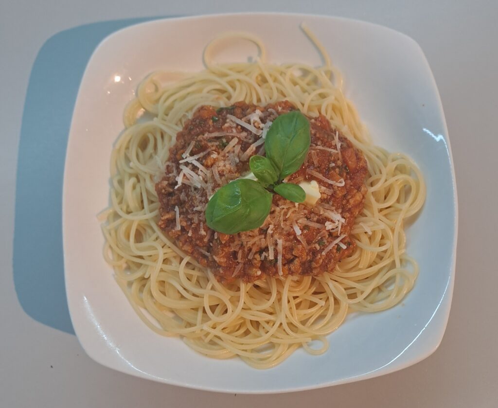 Strickarin_Spaghetti_Bolognese_mit_Basilikum_angerichtet Spaghetti mit Ragu angerichtet