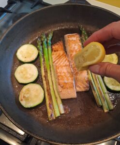 Zitrone auf den Fisch träufeln