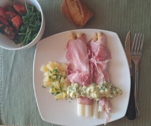 Spargel mit Schinken und Kartoffel und Zigorisalat angerichtet