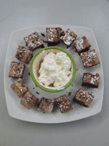 Strickarin_Schokokuchen_mit_Sahne Browniekuchenstückchen mit Sahne angerichtet