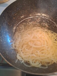 Spaghetti in die Pfanne zum Bauchspeck