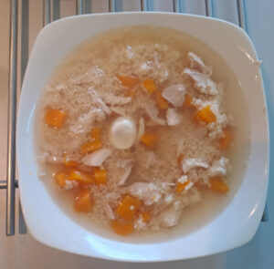 Hühnerbrühe mit Fleisch, Karotten, Suppennudel und Wachtelei