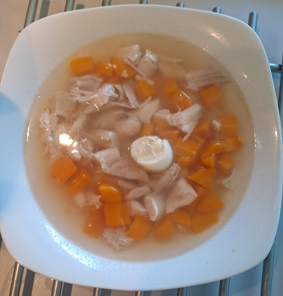 Hühnerbrühe mit Fleisch, Karotten und Wachtelei