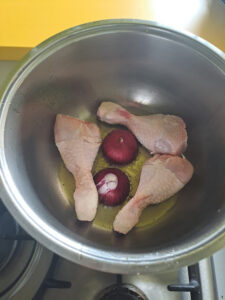 Zwiebel und Huhnschenkel anbraten