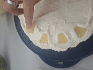 Ananasstücke in die Creme drücken