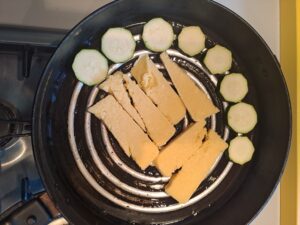 Polenta und Zucchini in die heiße Pfanne legen