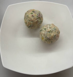 Speckknödel am Teller anrichten