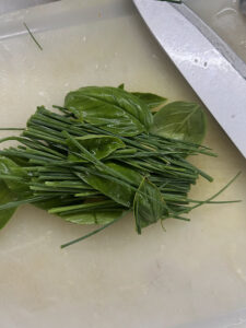 gewaschene Basilikumblätter und Schnittlauch