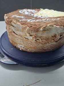 Torte auf der Seite bestreichen und bestreuen