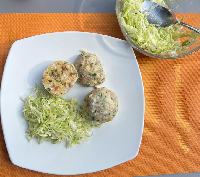 Speckknödel mit reichlich Krautsalat servieren